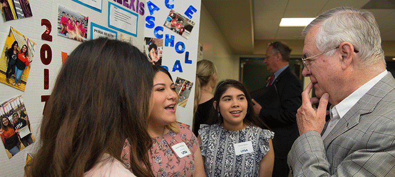 Alvarez talks to a group of students during the Alvarez Student Expo, which allows students to present their research projects.