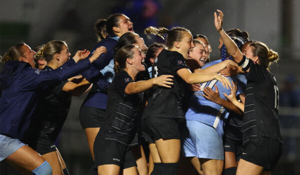 The UTSA soccer embraces each other in the rain.