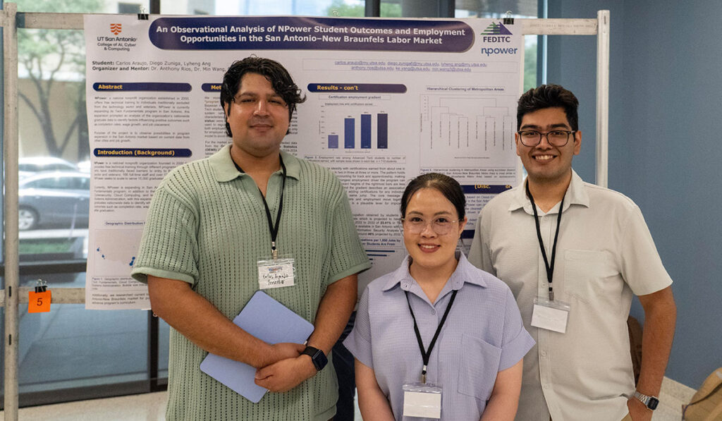 Three student researchers pose before a poster on NPower.