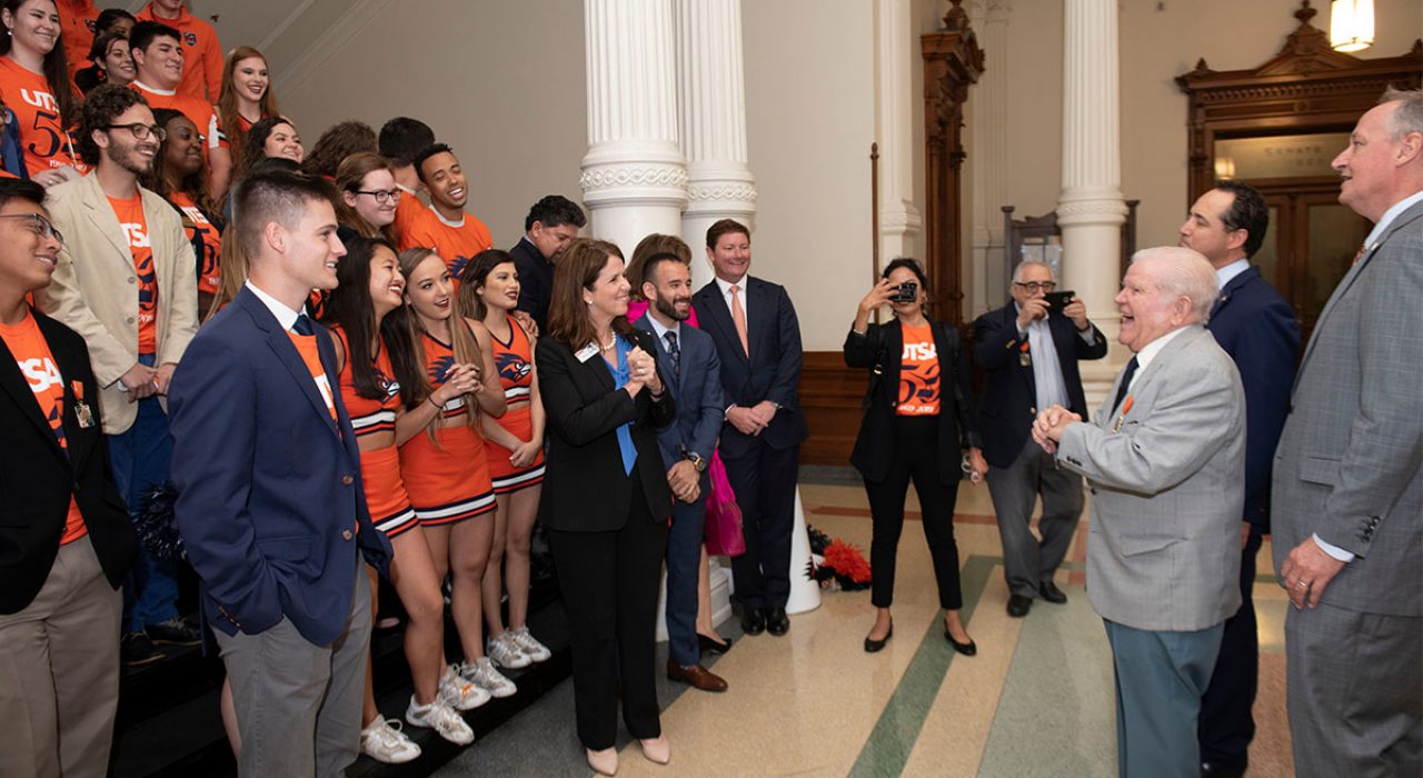 Joe Bernal laughs while looking at large group of students on a staircase