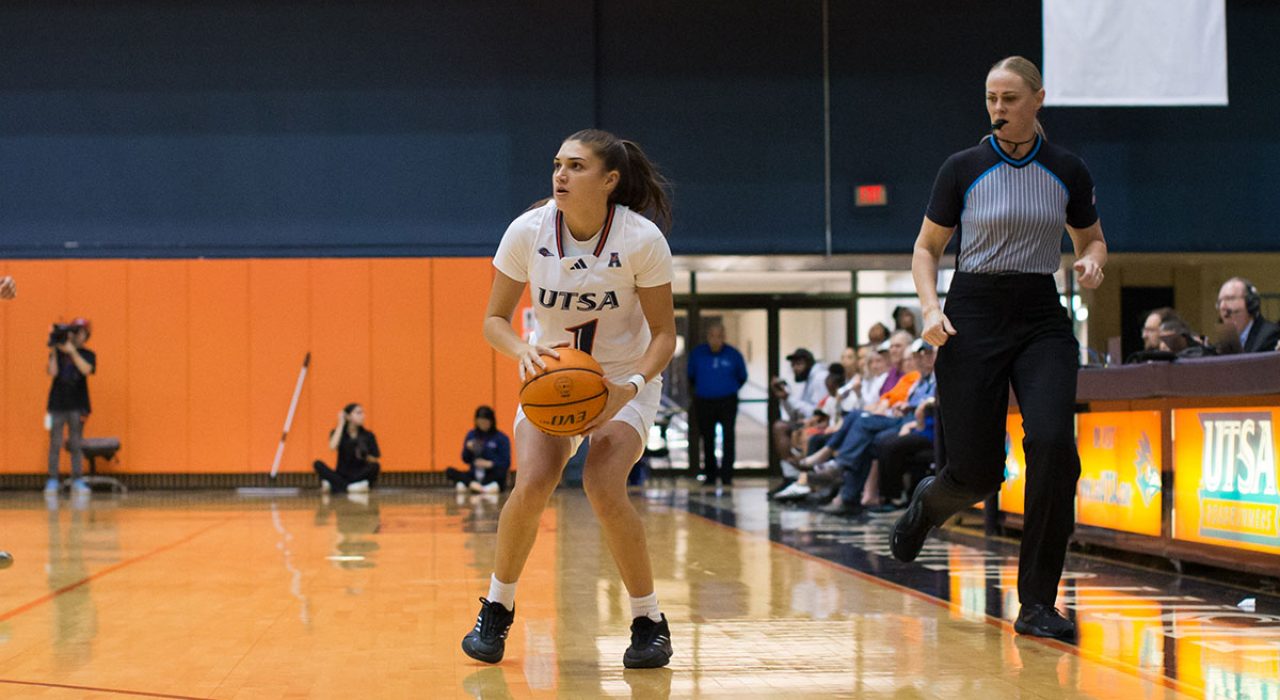 A female basketball player runs with a ball in her hands.