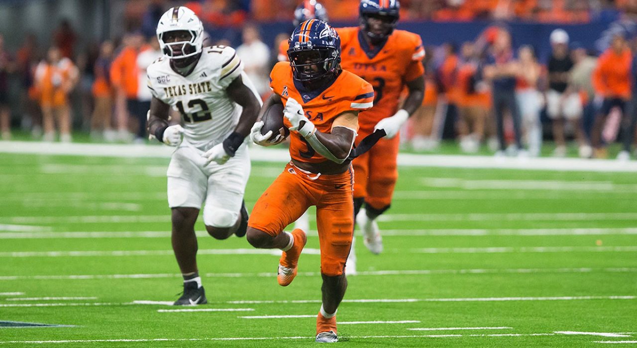 Robert Henry Jr. carries the football while outrunning a Texas State defender