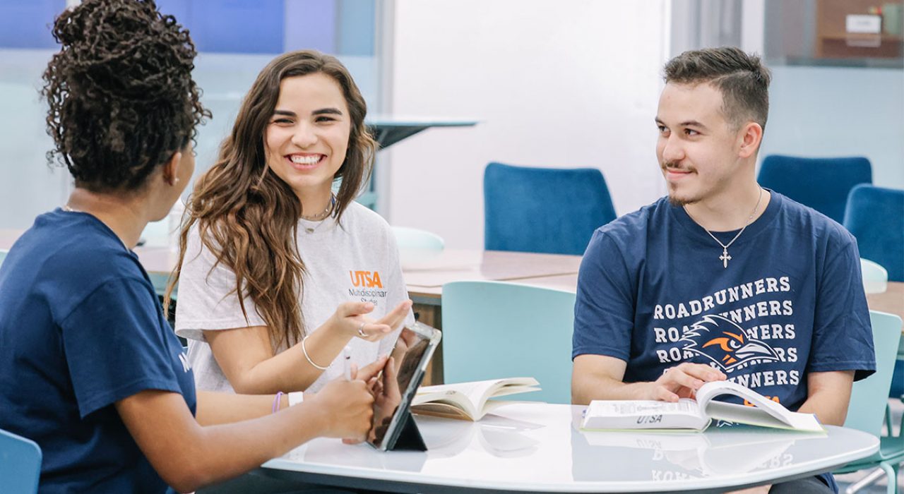 university-college-students-2023 Three University College students talk while sitting at a round table