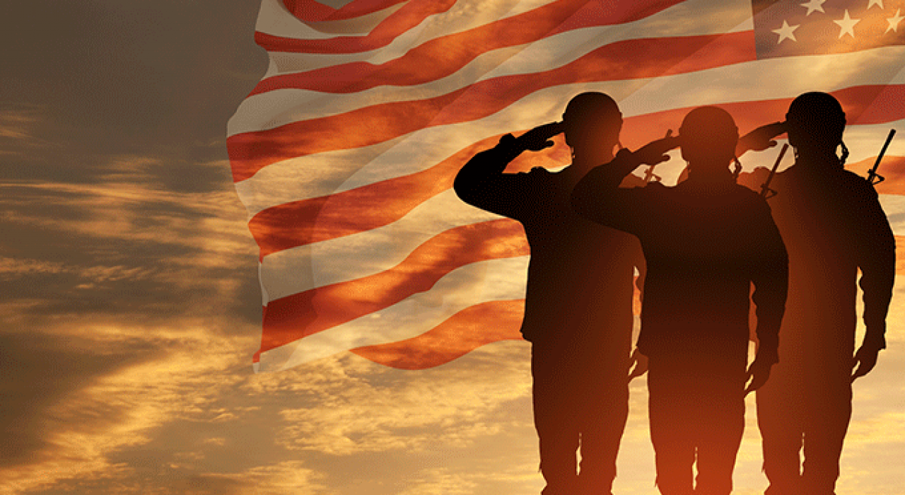 soldiers saluting with flag in background